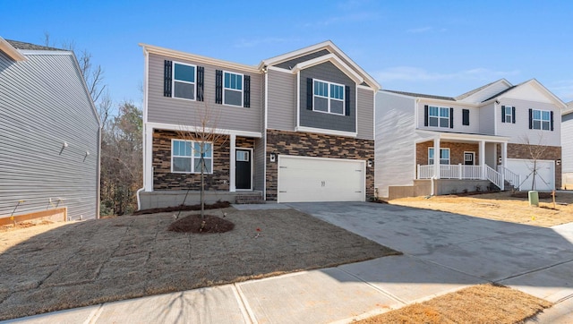 view of front of property featuring stone siding, a porch, concrete driveway, and an attached garage