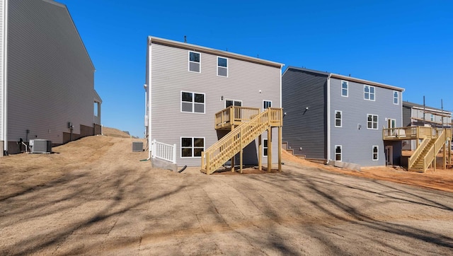 rear view of property with stairway, central air condition unit, and a wooden deck