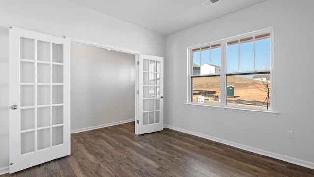 spare room with visible vents, baseboards, dark wood-style flooring, and french doors