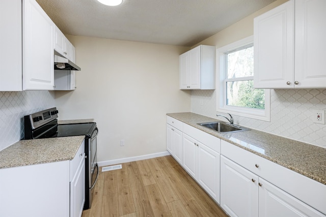 kitchen with under cabinet range hood, a sink, white cabinets, stainless steel electric range oven, and baseboards