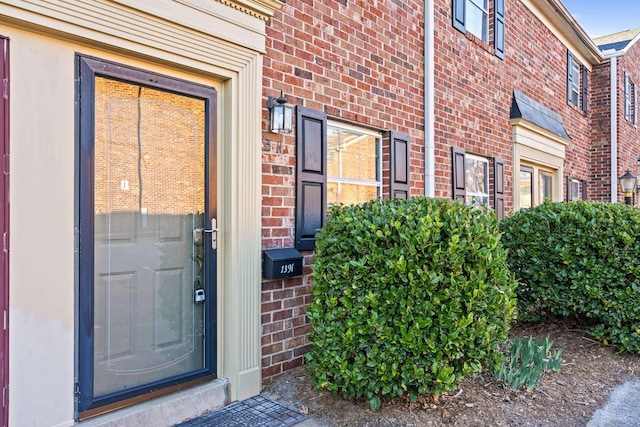 property entrance featuring brick siding