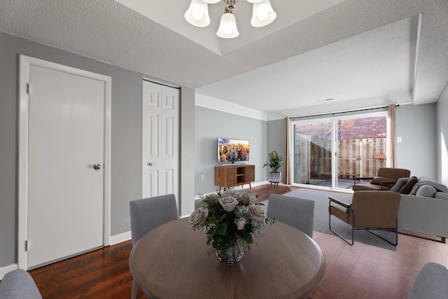 dining area with wood finished floors, baseboards, and a textured ceiling