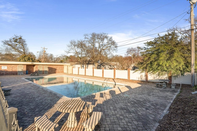 view of swimming pool featuring a fenced in pool, a fenced backyard, and a patio area