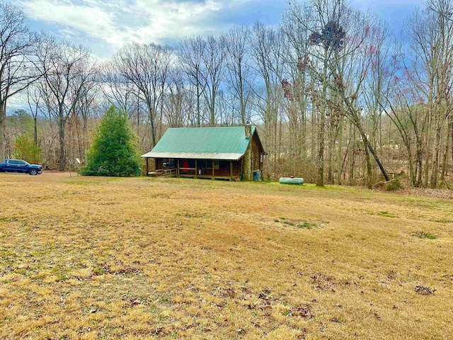 view of front of house with a front yard, an outdoor structure, and metal roof