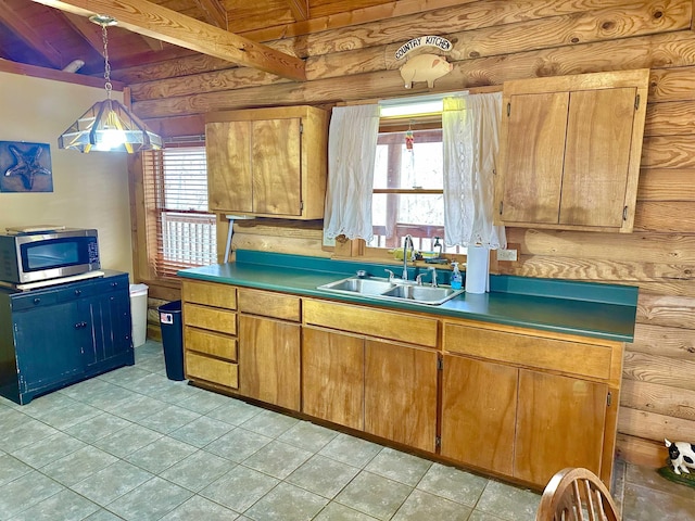 kitchen with beam ceiling, stainless steel microwave, a wealth of natural light, and a sink