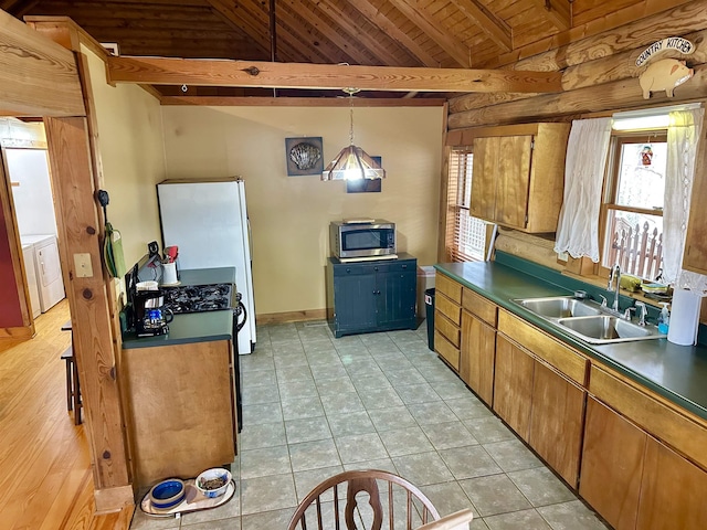 kitchen featuring dark countertops, stainless steel microwave, lofted ceiling with beams, wooden ceiling, and a sink