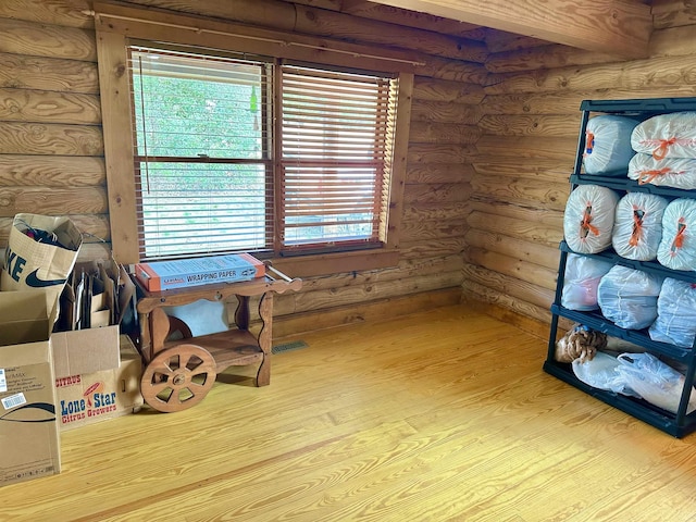 interior space featuring wood finished floors, visible vents, and rustic walls