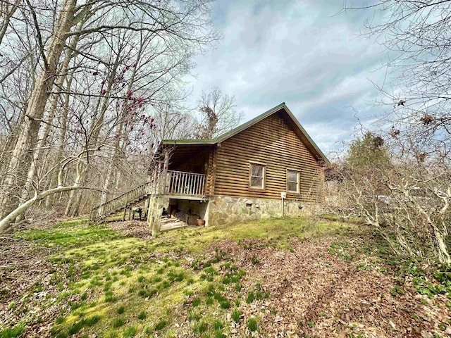 view of side of property with crawl space, log exterior, and stairs