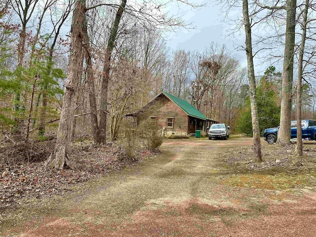 exterior space featuring a forest view and driveway