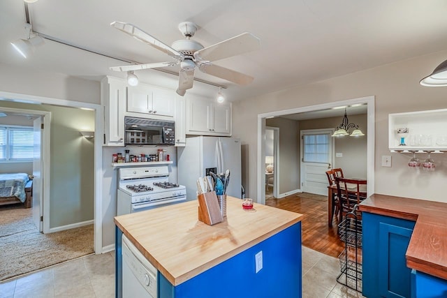 kitchen with white appliances, a ceiling fan, wooden counters, and white cabinets