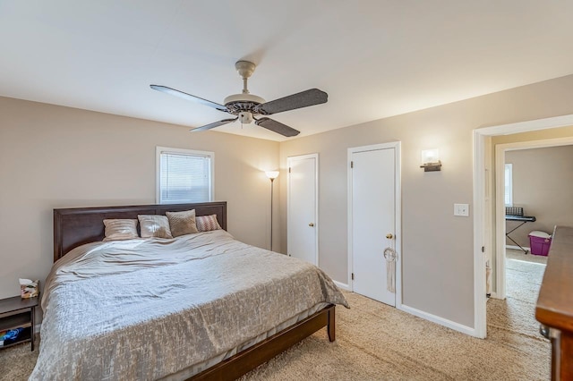 bedroom featuring light carpet, ceiling fan, and baseboards