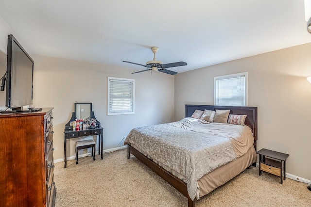 bedroom with multiple windows, light colored carpet, baseboards, and ceiling fan