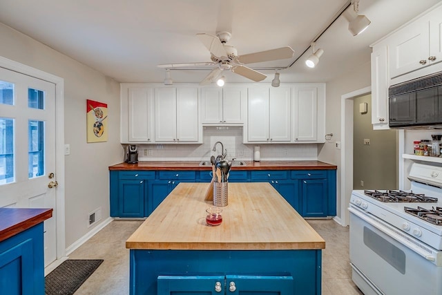 kitchen with blue cabinets, white gas range, and wooden counters