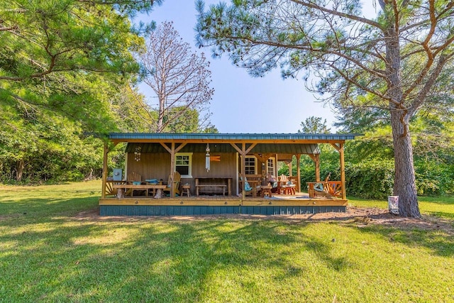 back of house with a wooden deck and a lawn