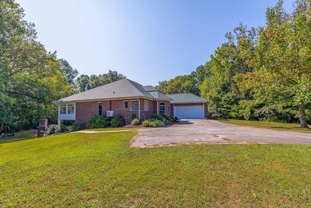 ranch-style home featuring brick siding, a garage, a front lawn, and driveway