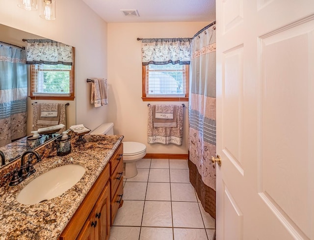 bathroom with tile patterned floors, toilet, visible vents, and a wealth of natural light