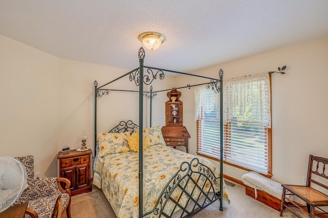 carpeted bedroom featuring visible vents, a textured ceiling, and baseboards