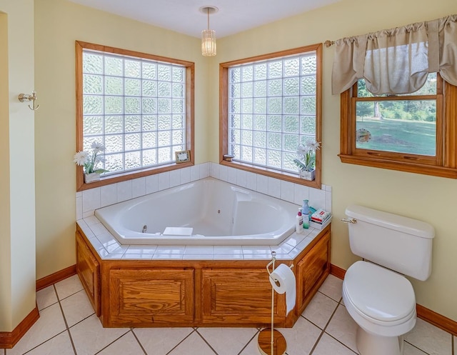 full bath with tile patterned flooring, toilet, and a whirlpool tub