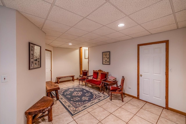 living area featuring recessed lighting, light tile patterned floors, a paneled ceiling, and baseboards