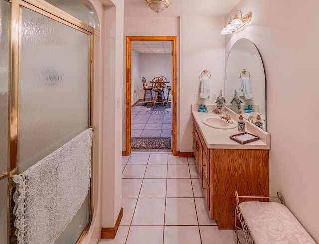 full bathroom featuring tile patterned flooring, a shower stall, vanity, and baseboards