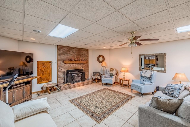 living room with tile patterned floors, baseboards, a paneled ceiling, and a ceiling fan