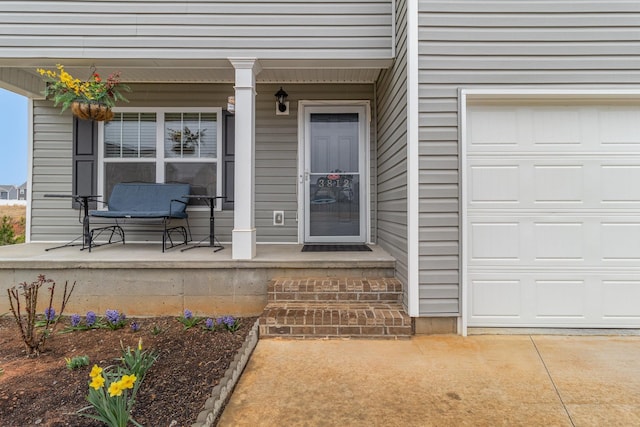 doorway to property with a porch and a garage