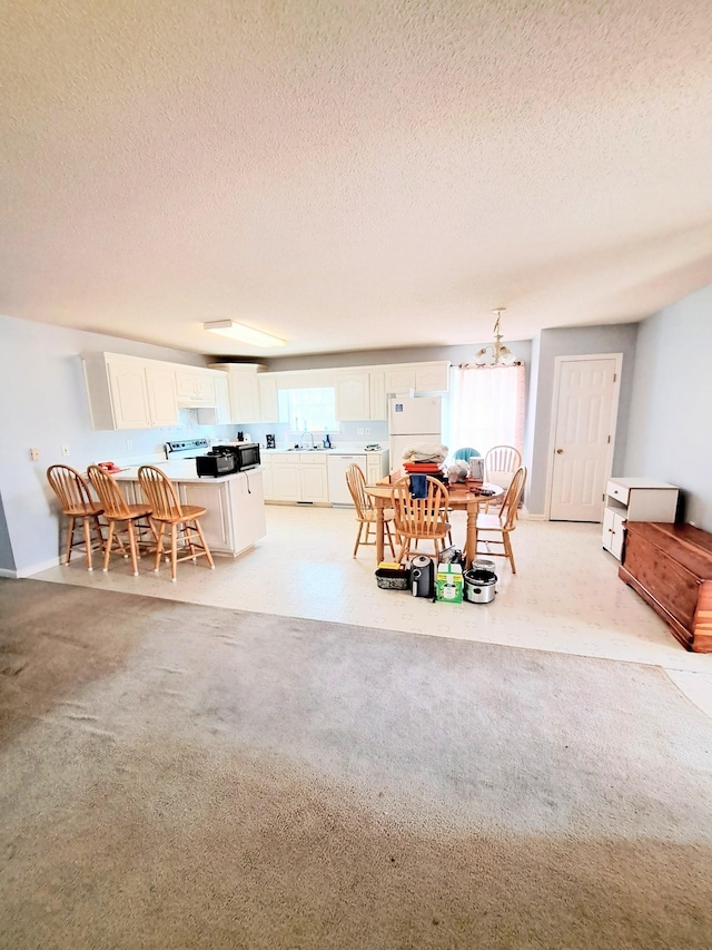 dining room with light colored carpet and a textured ceiling