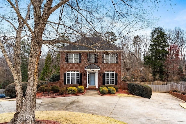 view of front of house featuring brick siding and fence