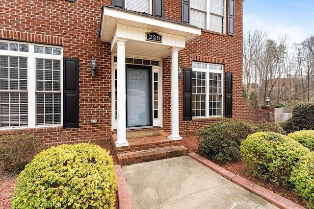 view of exterior entry featuring brick siding