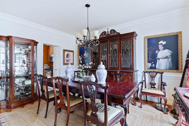 dining space featuring an inviting chandelier, wood finished floors, and crown molding