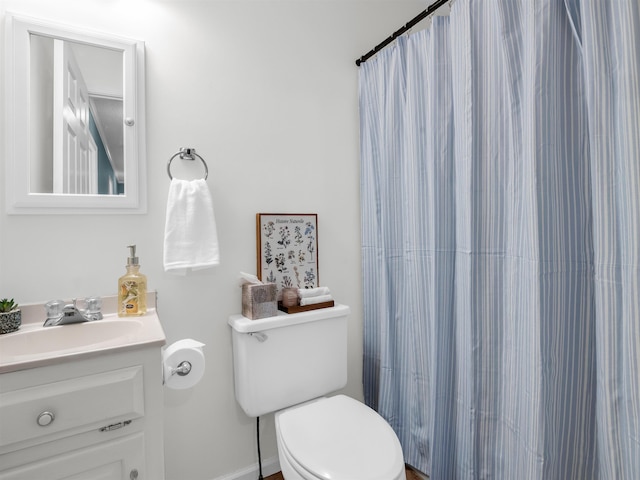 bathroom with toilet, vanity, and a shower with shower curtain