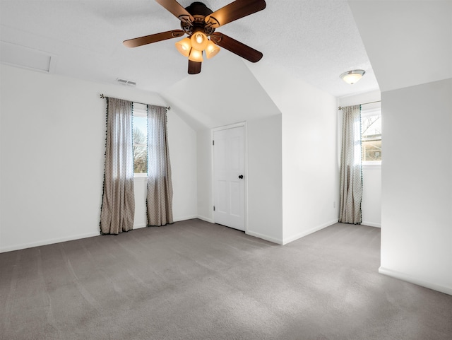 interior space with attic access, baseboards, visible vents, and lofted ceiling