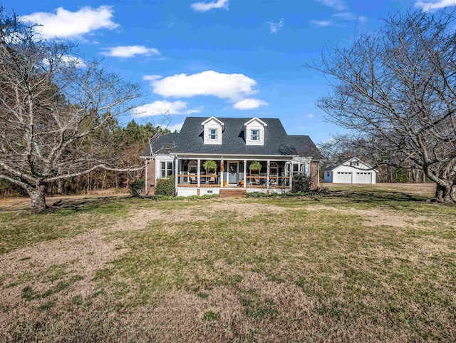 back of house with a porch, a yard, a garage, and an outdoor structure