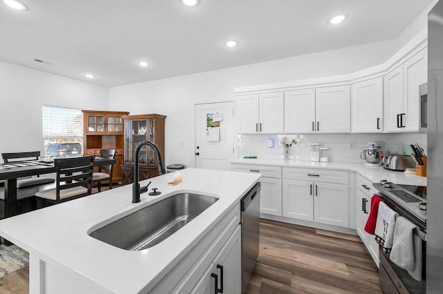 kitchen featuring a sink, dark wood-type flooring, white cabinets, appliances with stainless steel finishes, and tasteful backsplash