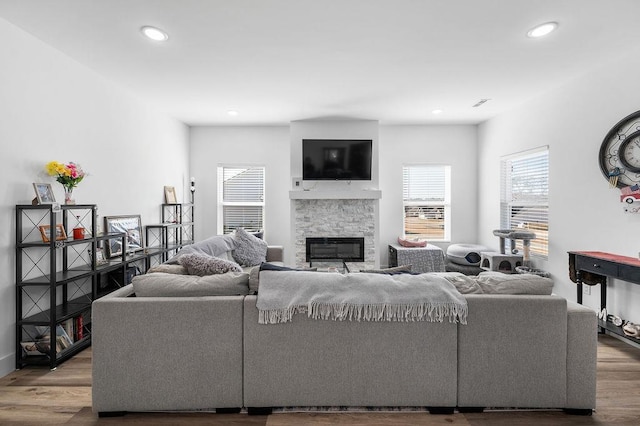 living area featuring recessed lighting, wood finished floors, and a fireplace