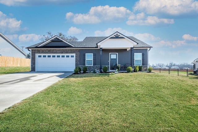 view of front of property with a front yard, fence, driveway, an attached garage, and board and batten siding