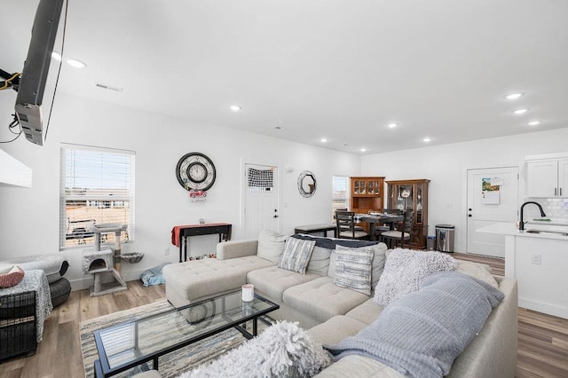 living area featuring recessed lighting, visible vents, and wood finished floors