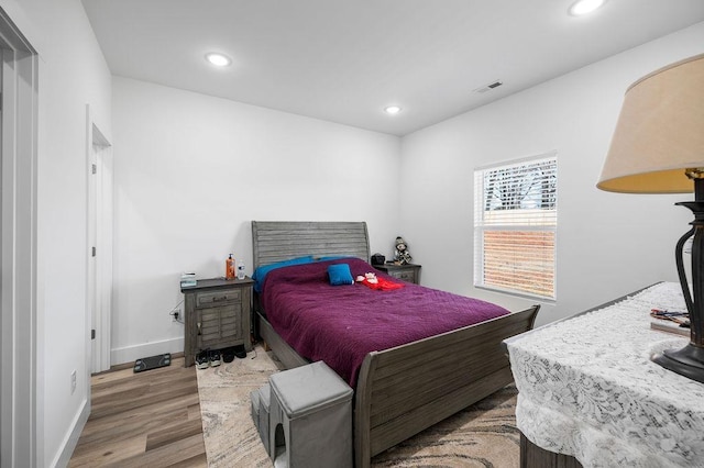 bedroom with visible vents, recessed lighting, baseboards, and wood finished floors