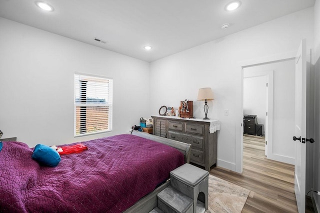 bedroom with recessed lighting, light wood-style flooring, baseboards, and visible vents