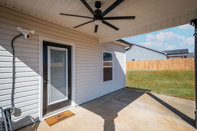 property entrance with a patio area, a yard, ceiling fan, and fence