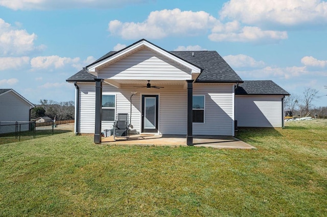 rear view of house with fence, roof with shingles, a lawn, a ceiling fan, and a patio