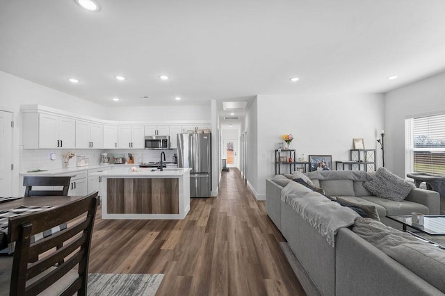 kitchen with dark wood-style floors, open floor plan, white cabinetry, appliances with stainless steel finishes, and light countertops