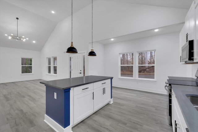 kitchen with dark countertops, light wood-style flooring, high vaulted ceiling, and stainless steel range with electric cooktop