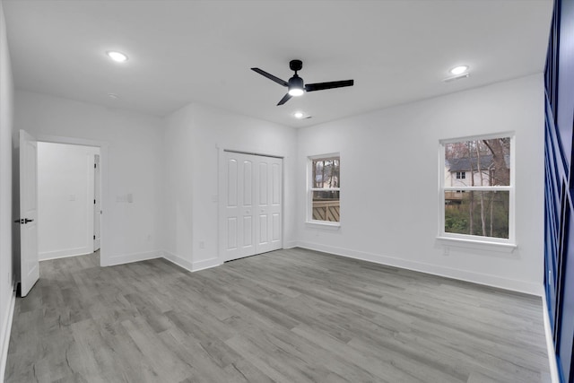 unfurnished bedroom with recessed lighting, wood finished floors, baseboards, and a closet