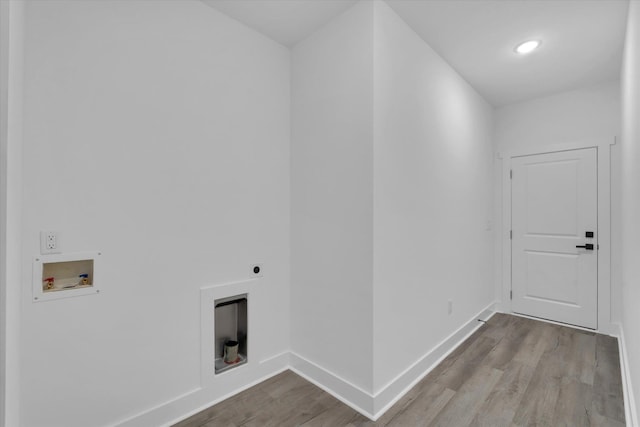 clothes washing area featuring wood finished floors, baseboards, hookup for an electric dryer, hookup for a washing machine, and laundry area