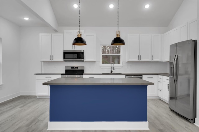 kitchen featuring backsplash, appliances with stainless steel finishes, a kitchen island, and a sink