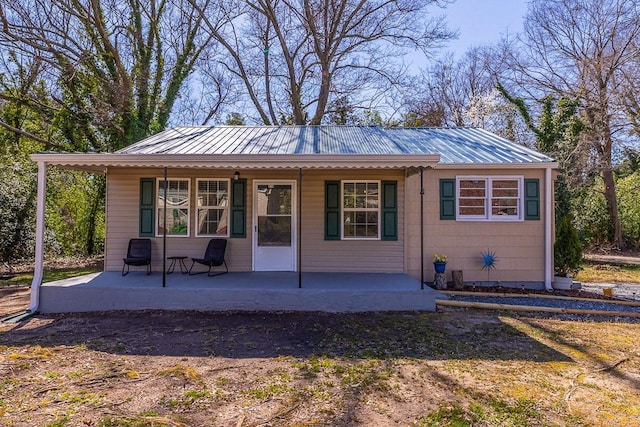 rear view of property featuring metal roof