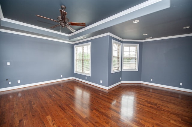 unfurnished room with a ceiling fan, wood finished floors, baseboards, a tray ceiling, and crown molding