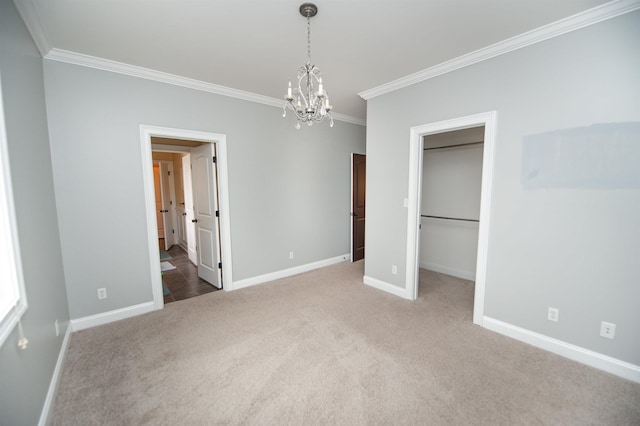 unfurnished bedroom featuring baseboards, a spacious closet, ornamental molding, and carpet flooring