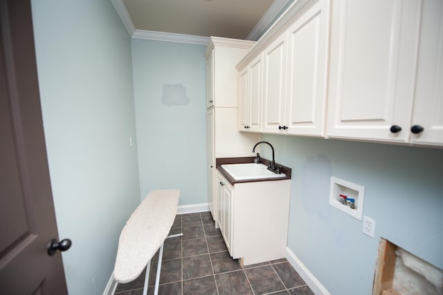 washroom with baseboards, cabinet space, ornamental molding, washer hookup, and a sink